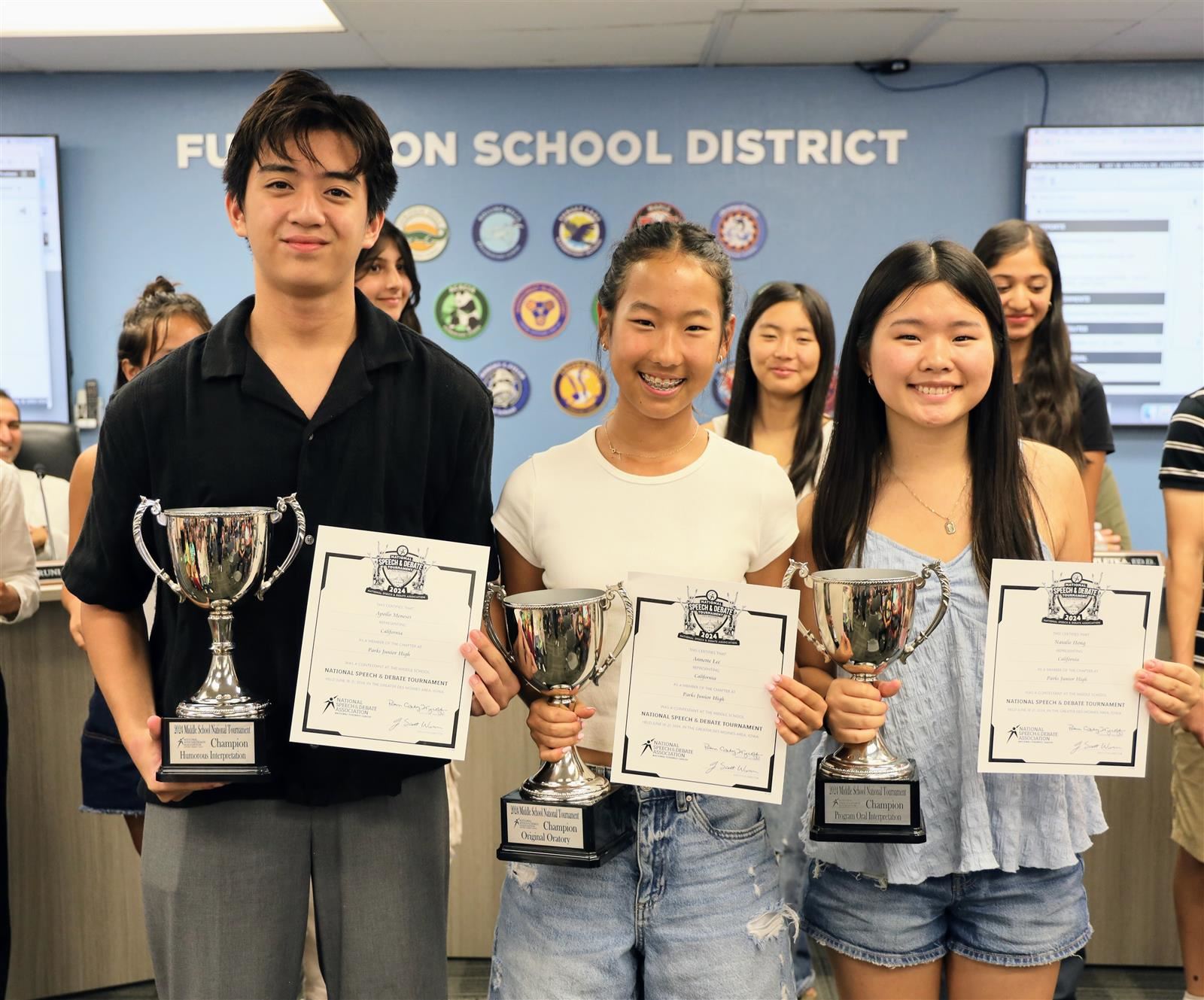 From left to right: Apollo Meneses, Annette Lee, and Natalie Hong holding their NSDA championship trophies.